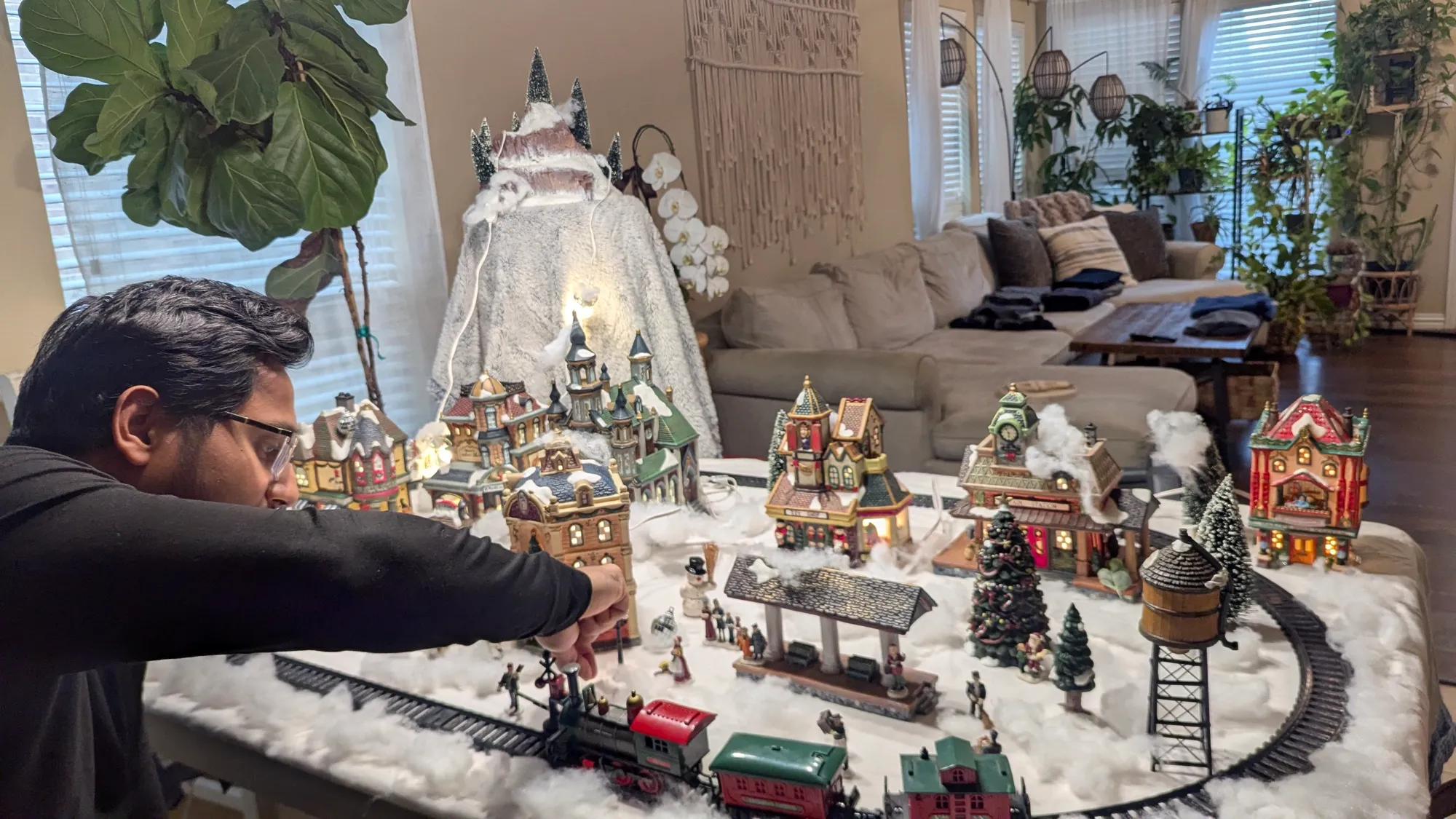 A model railway village scene with lit buildings and a locomotive