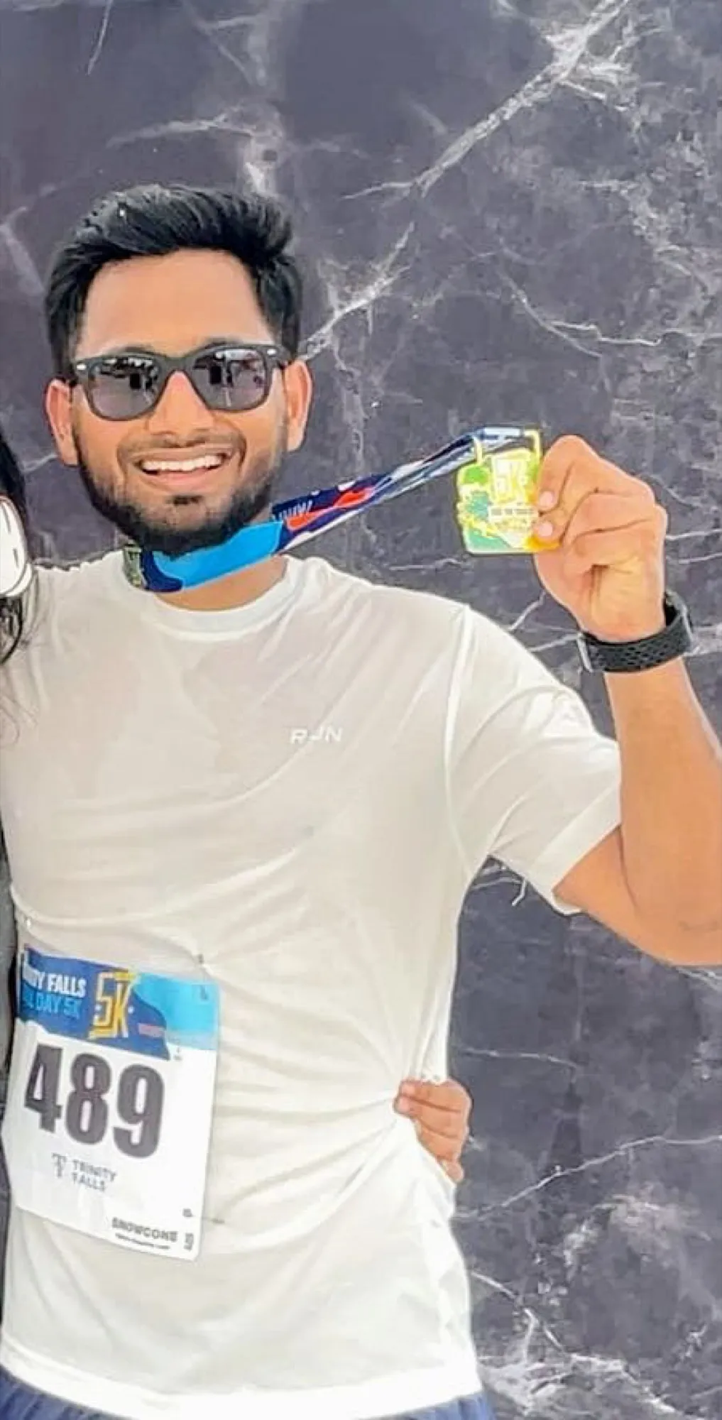 Varun Singh holding a 5K finisher medal