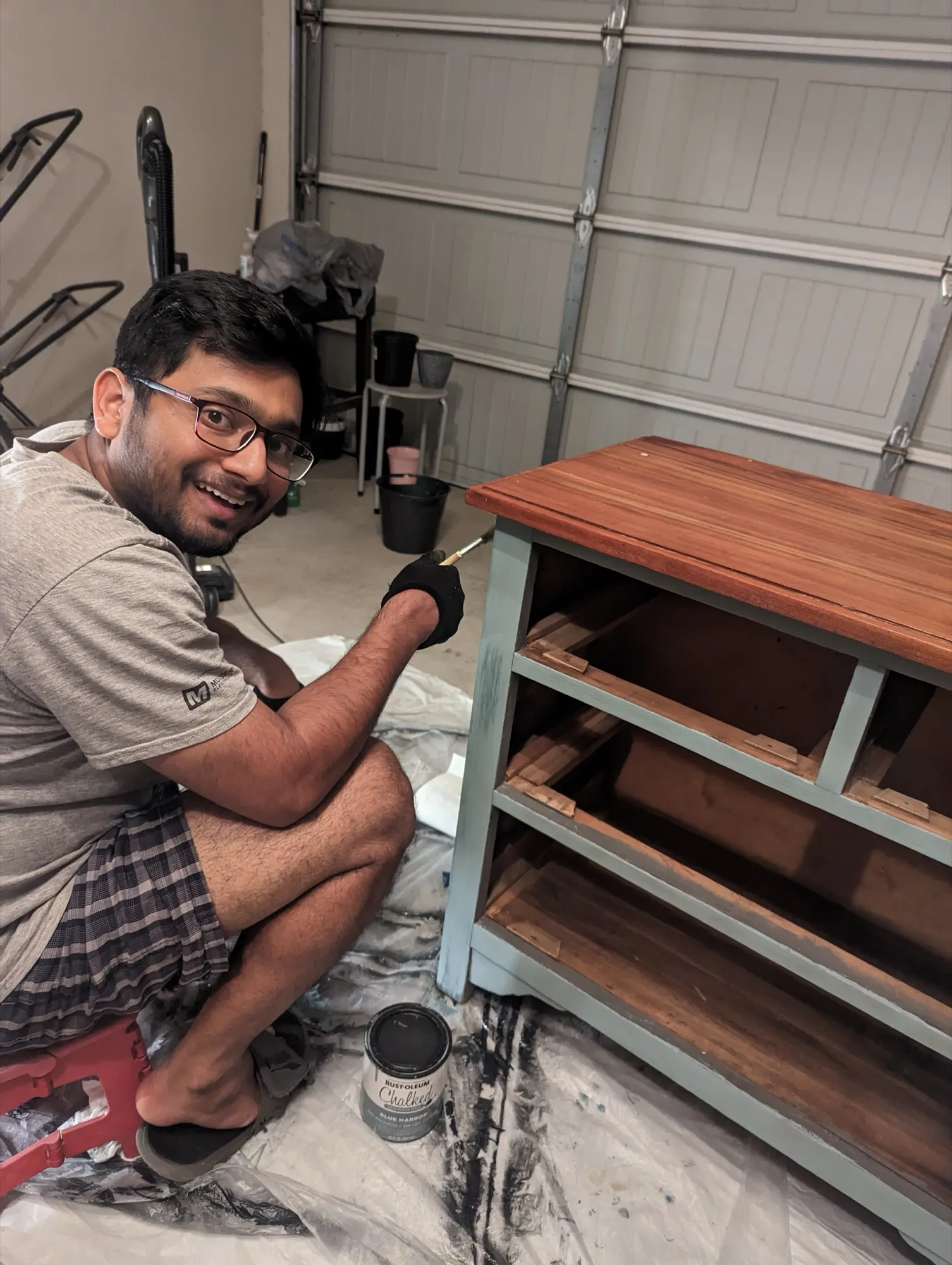 Varun Singh painting a refinished wooden dresser